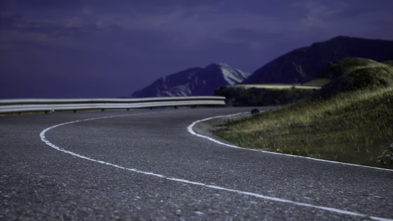 Serpentine road winding through mountainous landscape in twilight hours