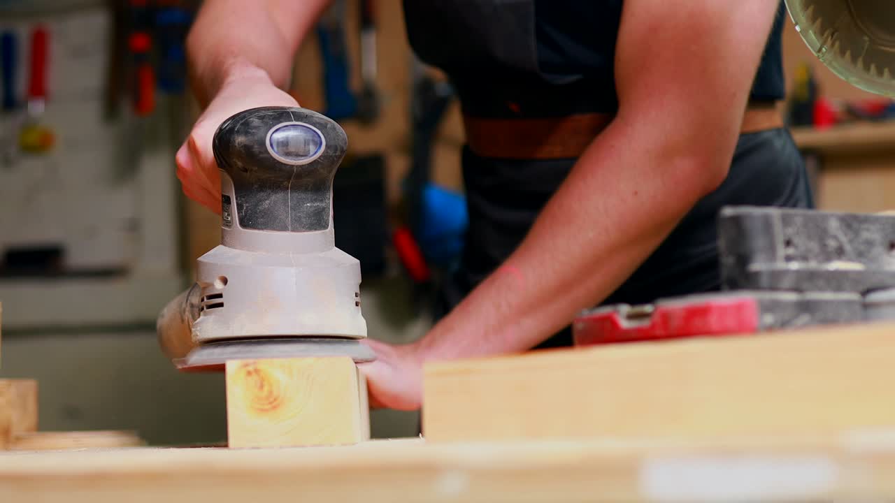carpintero joven trabajando con madera en el taller