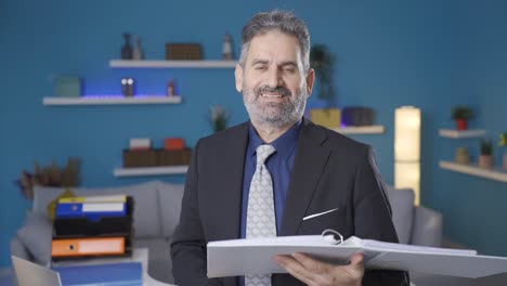 Businessman-working-from-home-takes-off-his-glasses-and-smiles-looking-at-camera.