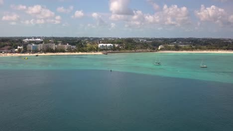 aerial view towards the coastline of sunny nassau, bahamas - rising, drone shot