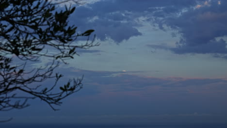 mesmerizing time-lapse of moon shining through dramatic clouds at daybreak