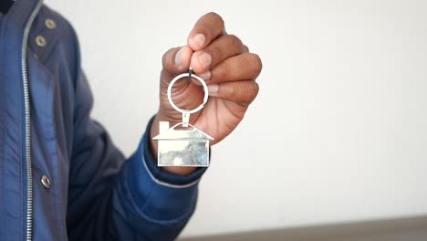 persona que tiene una llave en forma de casa