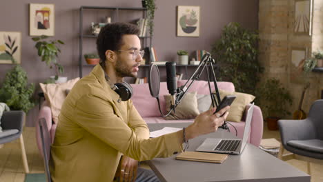 Side-View-Of-Man-Recording-A-Podcast-Wearing-Eyeglasses-And-Headphones