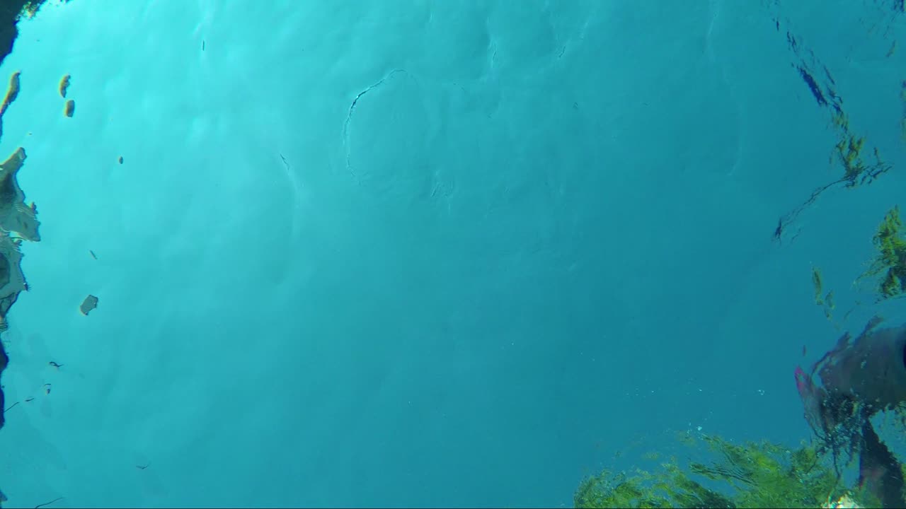 Nadando en la piscina capturado desde abajo