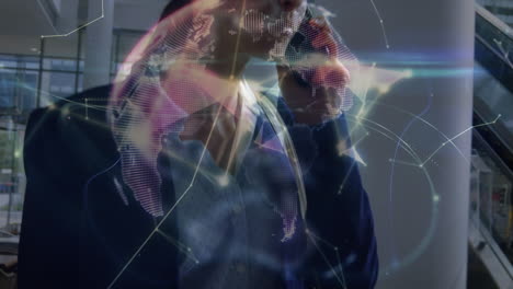 animación de conexiones y globo sobre feliz mujer de negocios caucásica usando teléfono inteligente