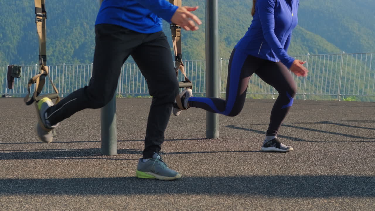 커플이 야외에서 서스펜션 다리 운동을 하고 있습니다.