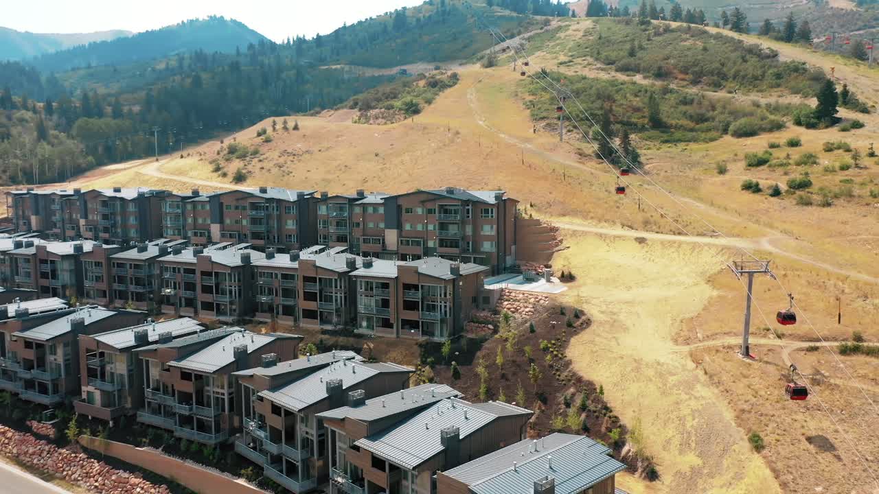 fila de nuevos alojamientos de vacaciones para turistas con teleférico en la montaña en verano