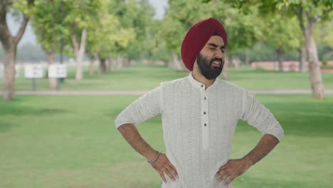 sick sikh indian man suffering from stomach pain in park