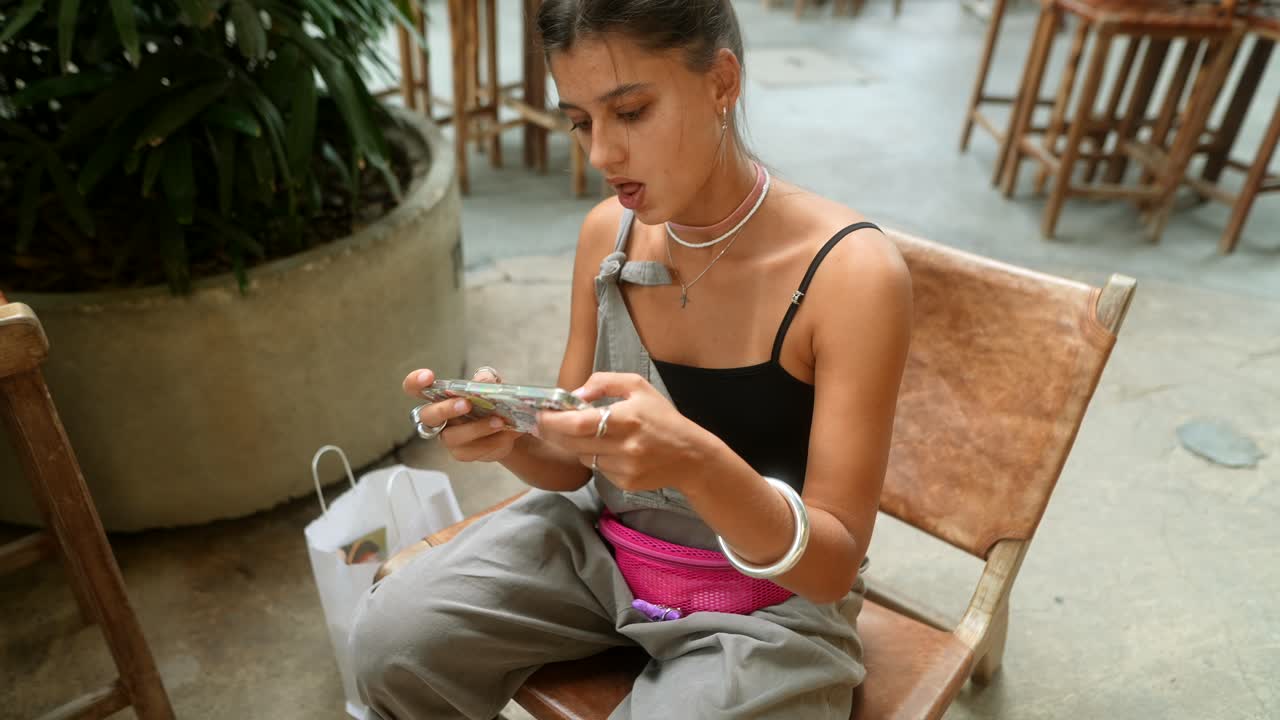A woman sitting on a chair using her phone