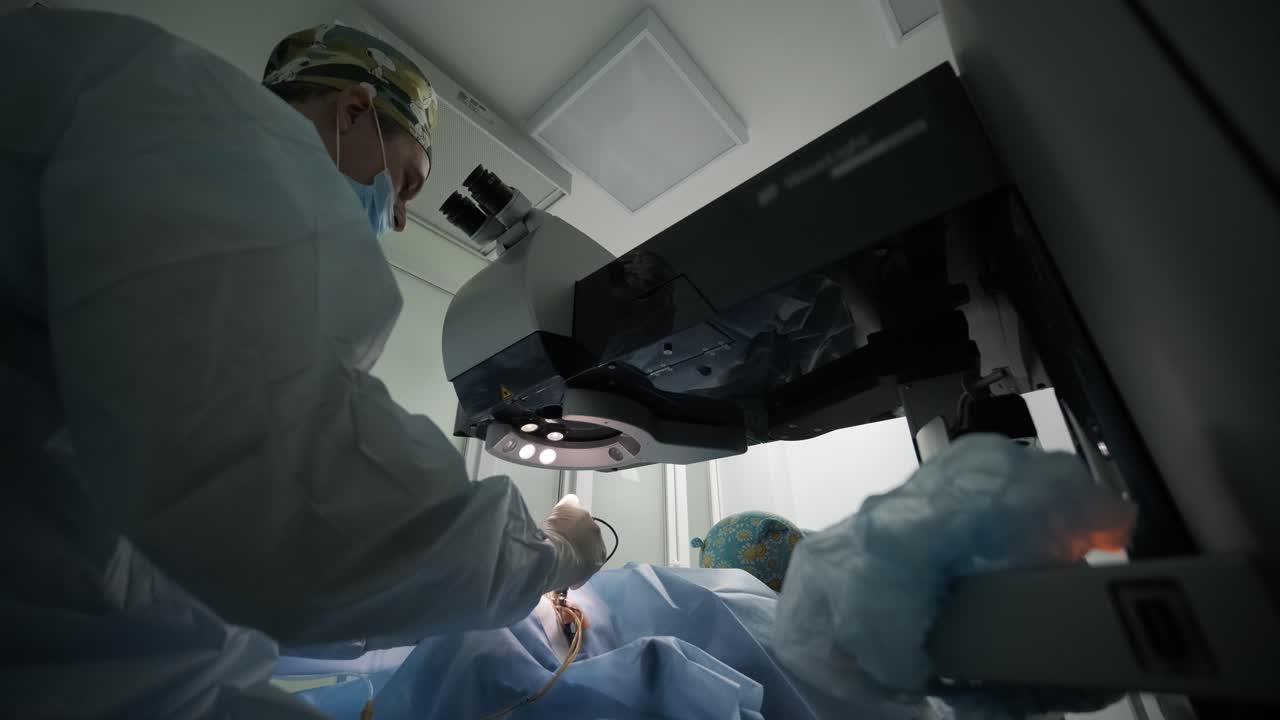 Laser vision correction. A patient and team of surgeons in the operating room during ophthalmic surgery. Eyelid speculum. Lasik treatment. Patient under sterile cover