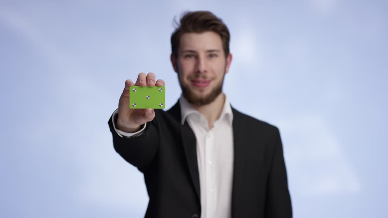 Young and attractive man presenting a buisness card into the camera