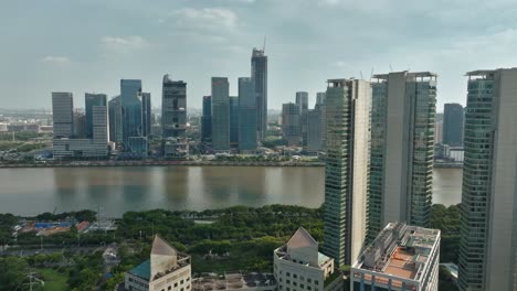 Aerial-tracking-shot-of-high-rise,-the-Pearl-River-and-condominium,-in-sunny-Guangzhou,-China