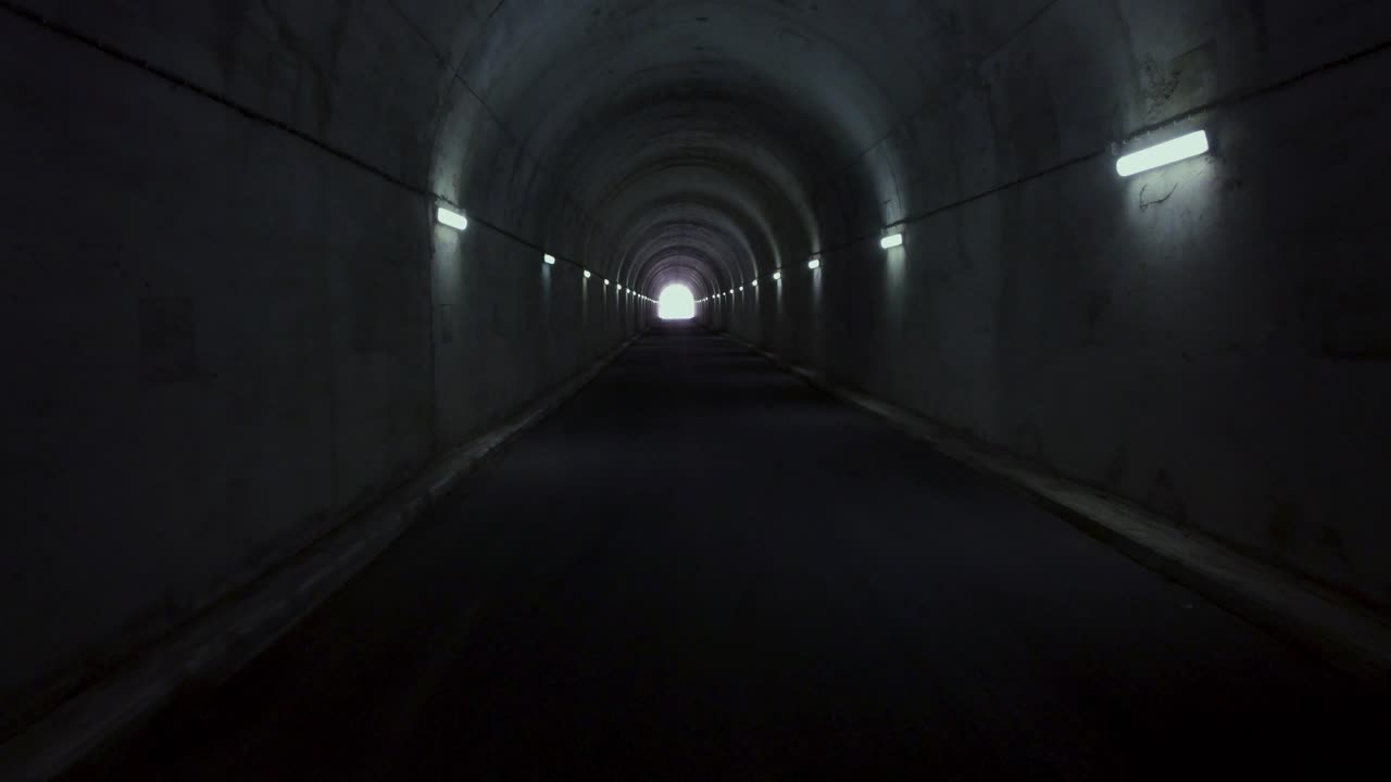 지평선에 빛이 있는 산의 긴 터널 안에서 느린 비행