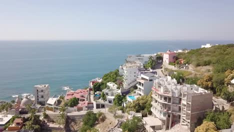 aerial drone orbit shot above mexican resort town along the pacific shoreline in the state of sinaloa, mexico with sea ocean view