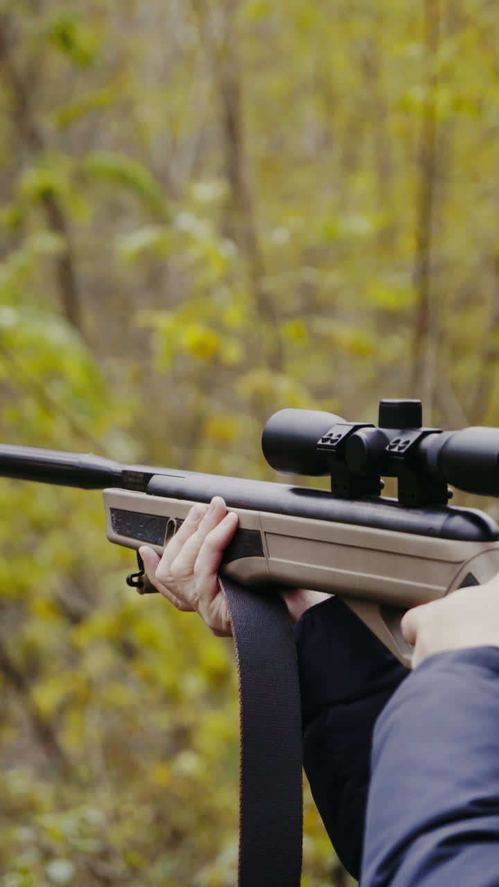 Man aiming with hunting rifle. Hunter man looking through the scope of hunting rifle