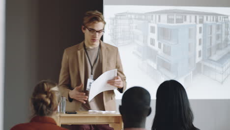 architect giving printed materials to people during presentation