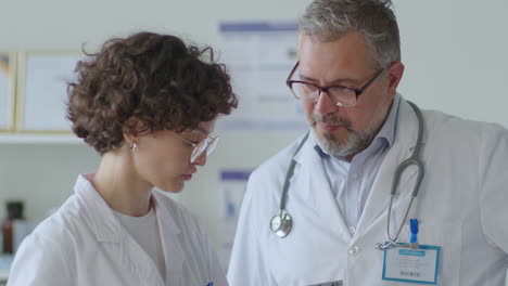 young female doctor discussing data on tablet with senior colleague
