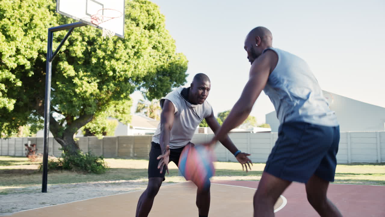 African American men playing basketball outdoors
