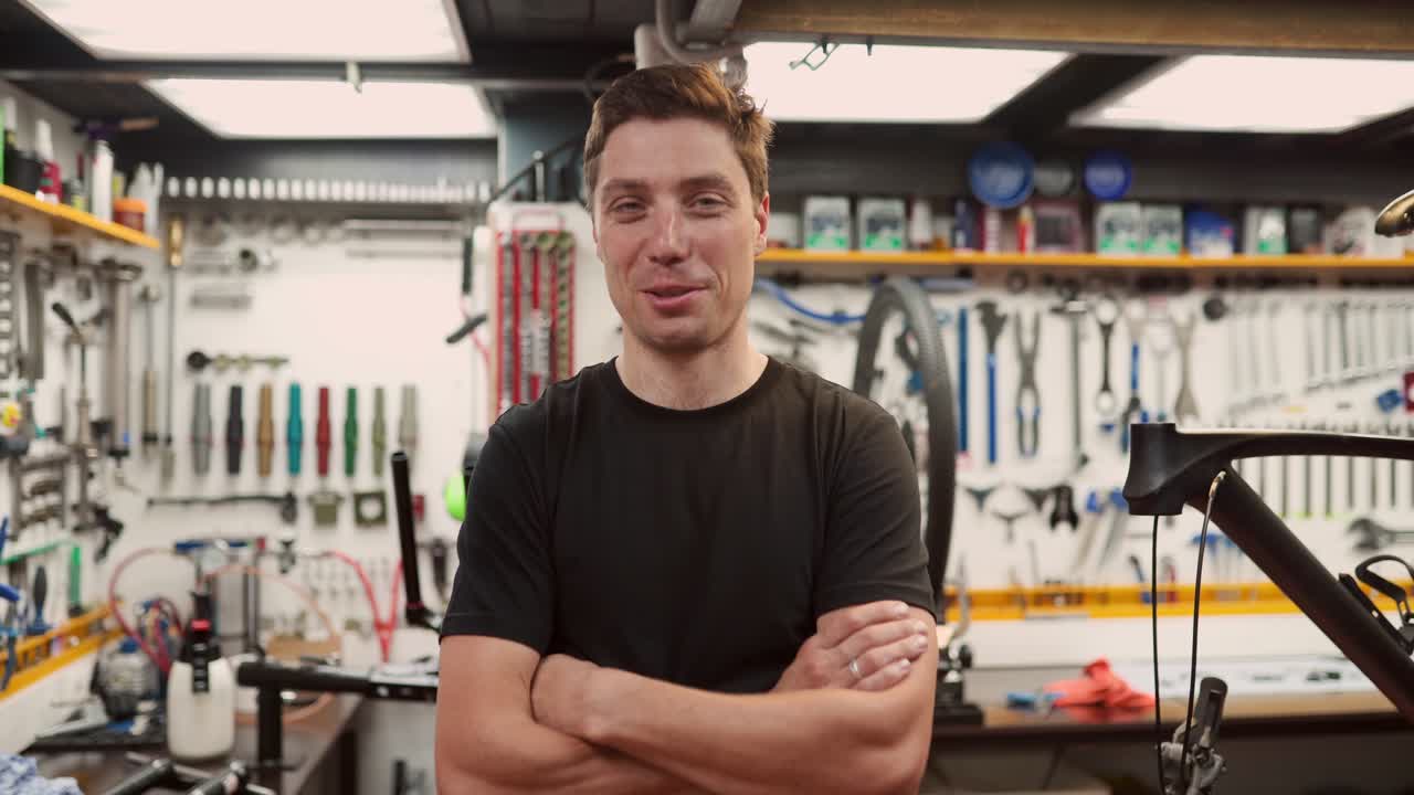 Uomo allegro in officina di riparazione biciclette