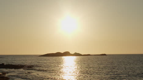 breve clip de puesta de sol cerca del mar con una pequeña isla en el frente