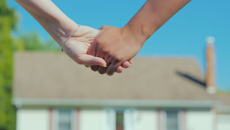 una pareja joven tomándose de la mano en el contexto de su nueva casa comprando un concepto inmobiliario a dre