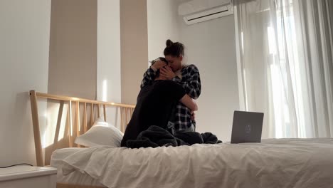 pareja abrazándose en el dormitorio