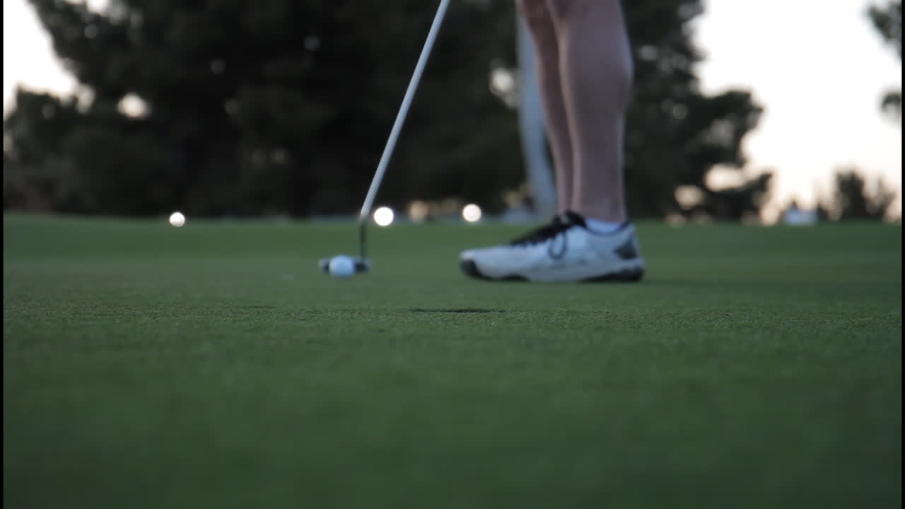 A person playing golf on a green course