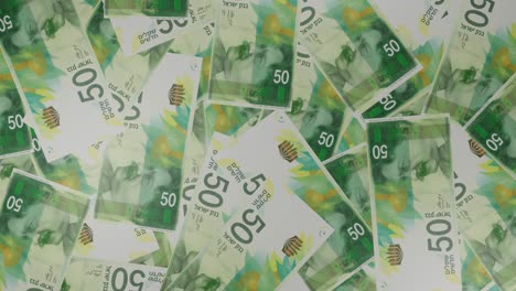 50 israeli shekels bills background. many banknotes.