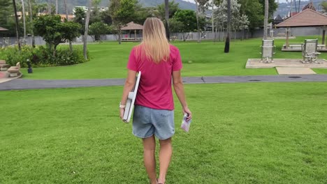 woman walking in a park with a board