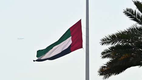 Die-Flagge-Der-Vereinigten-Arabischen-Emirate-Weht-Auf-Halbmast-über-Der-Flaggeninsel-In-Sharjah