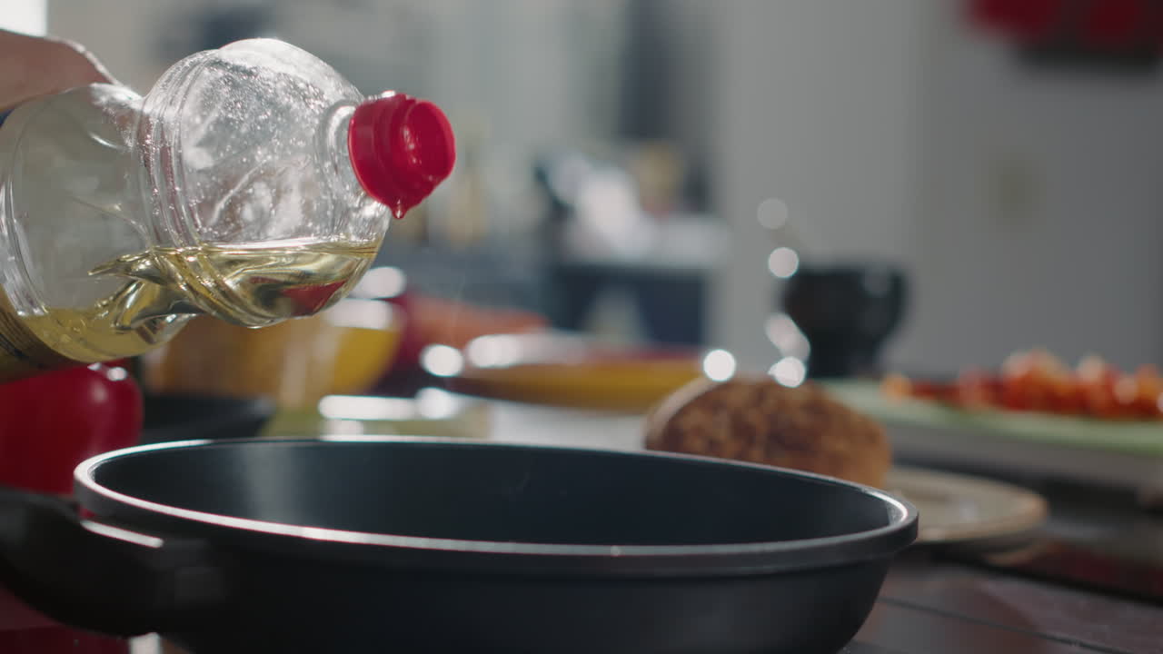 フライパンでオーガニックのオリーブオイルを加えるプロの料理人