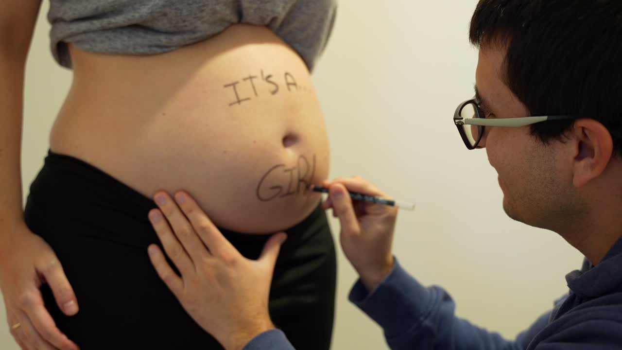 padre feliz escribe que es una niña en el vientre de su esposa embarazada para revelar el sexo del futuro bebé