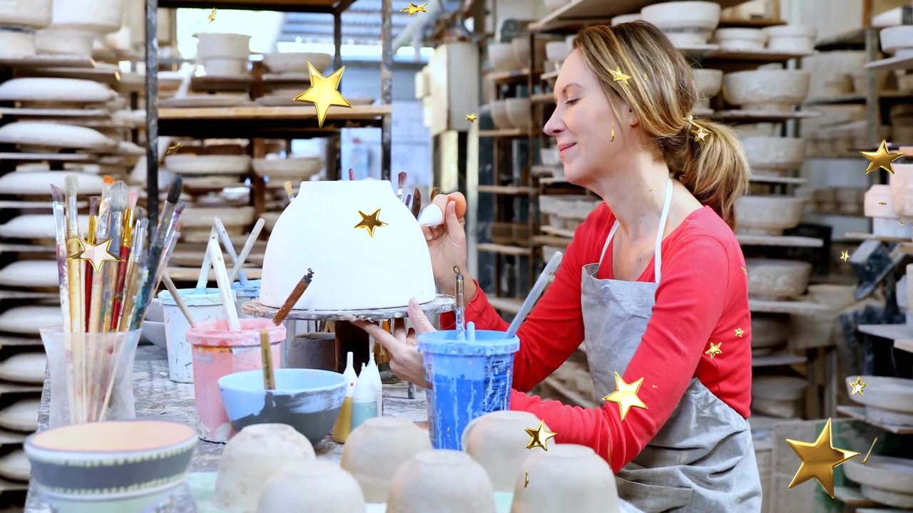Afferrando il pennello, artista della ceramica che intinge nello smalto blu e riveste una ciotola rotante per una finitura liscia