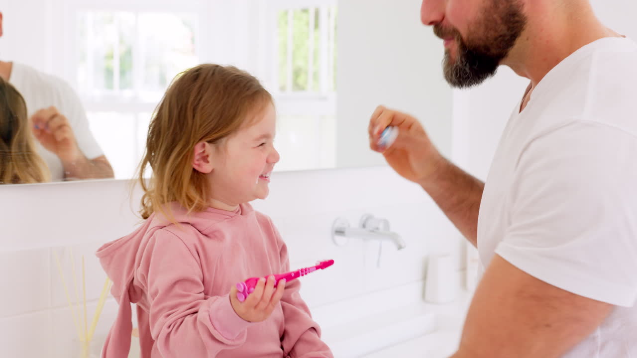 Father, learning and teaching girl to brush teeth