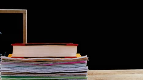 Test-tube-icons-against-back-to-school-text-on-wooden-slate-and-stack-of-books-on-wooden-table