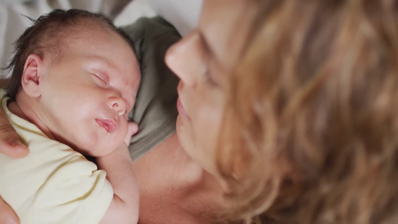잠자는 신생아 와 함께 침대 에 누워 있는 행복 한 백인 어머니 의 비디오