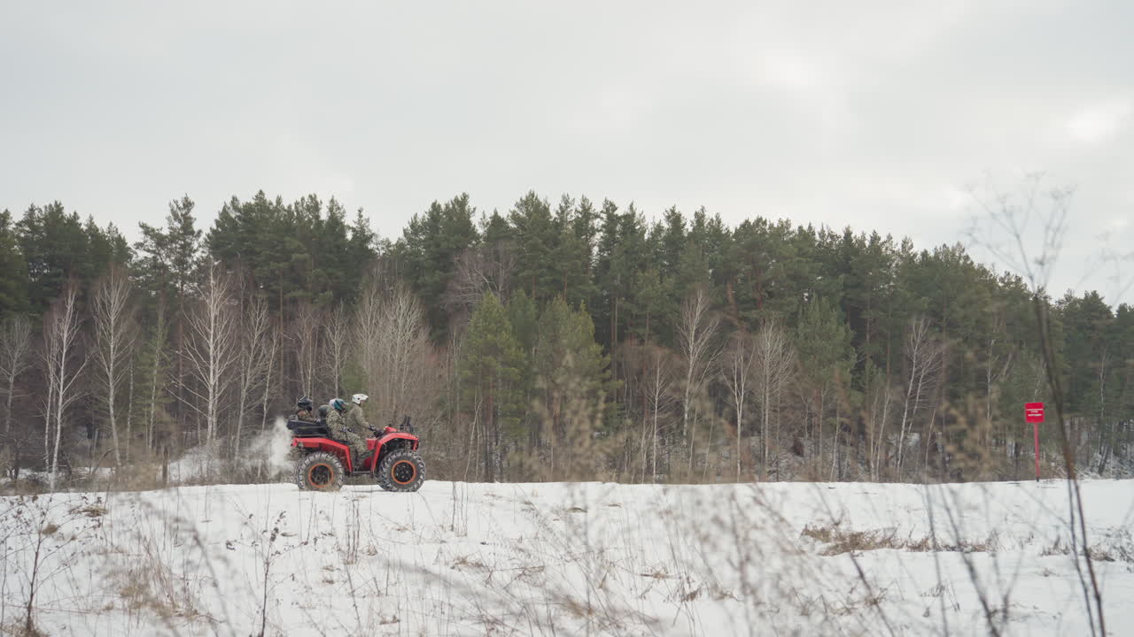 Avventura in quad sulla neve. Natura selvaggia remota con tracce ghiacciate e suoni del motore ovattati. Sereno ambiente invernale dove un pilota solitario osserva campi boscosi innevati sotto un cielo nuvoloso