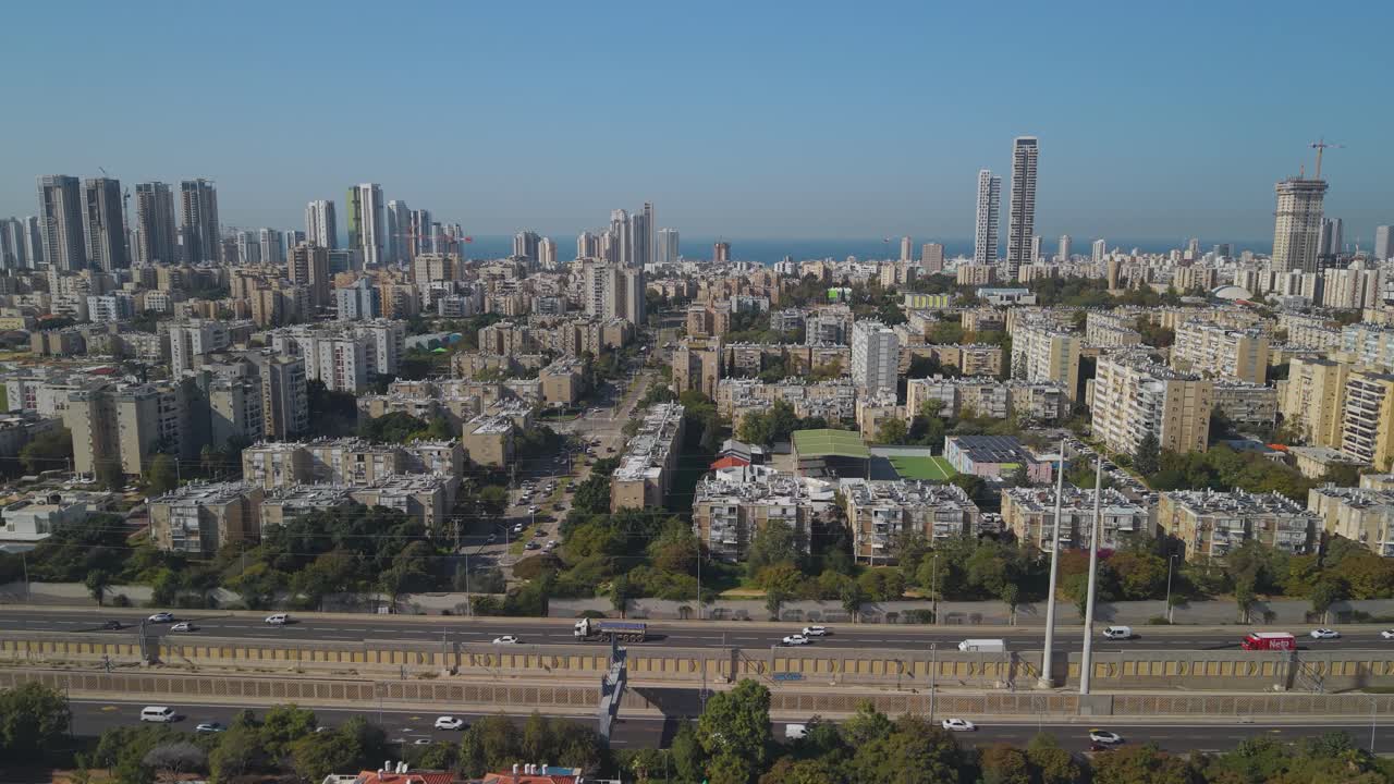 Prospettiva aerea laterale di un drone su Bat Yam, Israele, sopra la superstrada Ayalon che mostra l'area metropolitana con l'orizzonte marino in lontananza