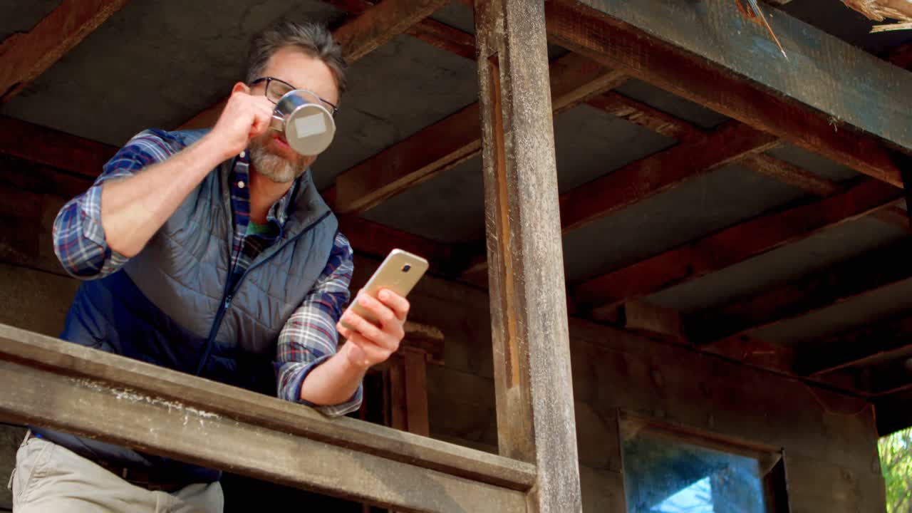 베란다 4k에서 노트북을 사용하는 동안 커피를 마시는 남자