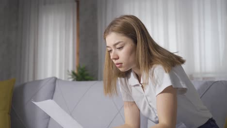 sad devastated young woman looking at paper.
