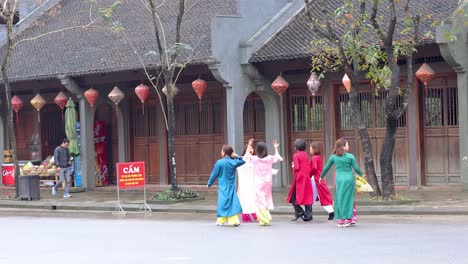 group in traditional vietnamese clothes strolling by temple