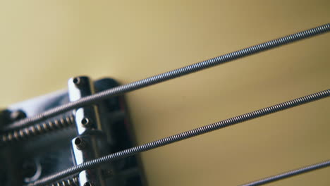 metal bass string trembles over silver bridge with springs