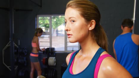 retrato de una mujer con ropa deportiva de pie en el gimnasio