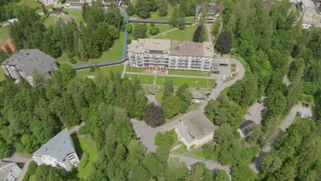 large hotel in the middle of the mountains surrounded by forest