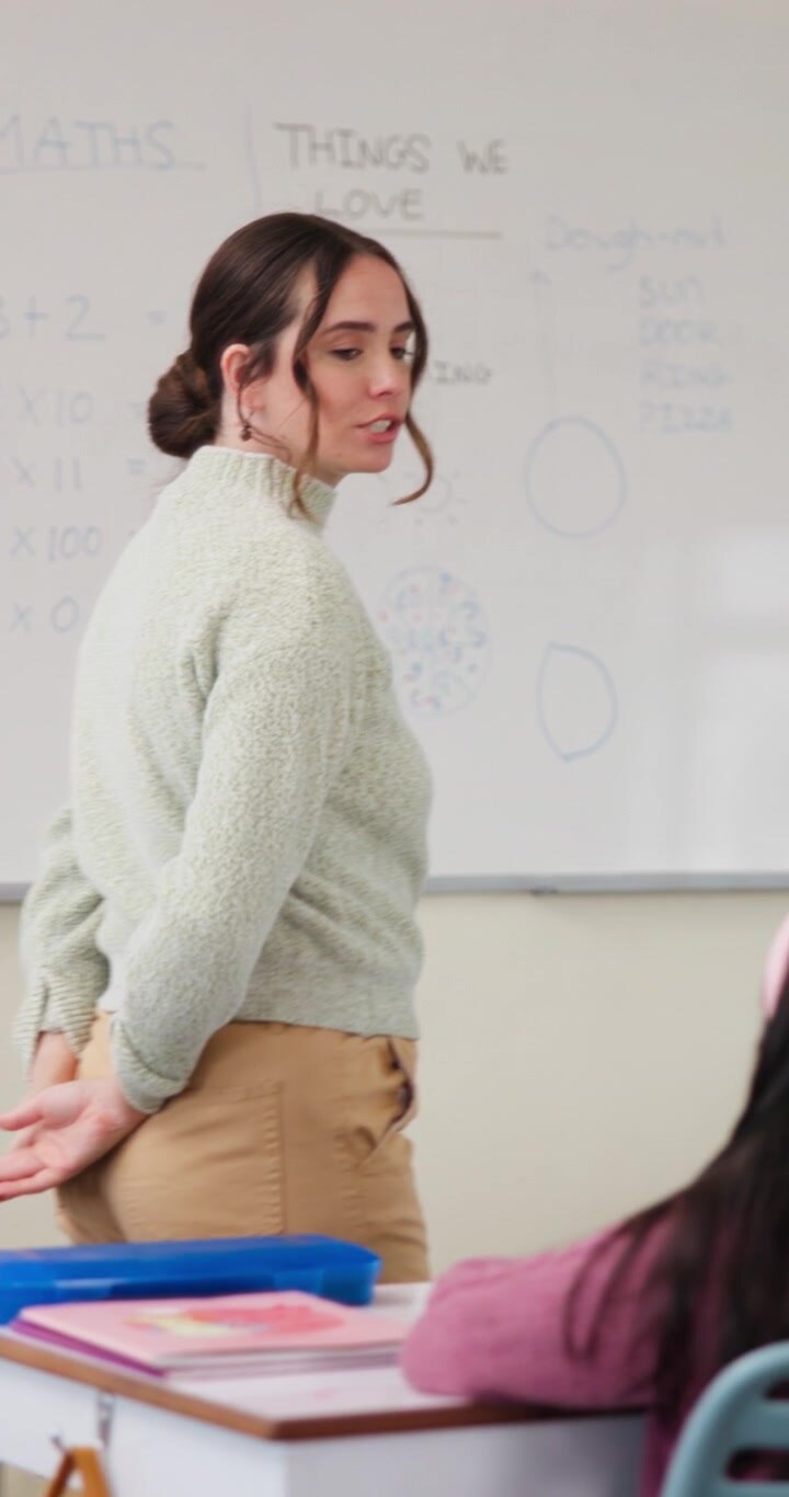 Teacher Standing in Front of Classroom Talking to Students