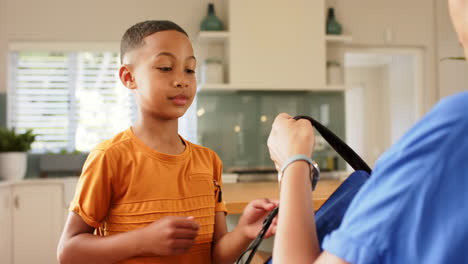 helping child with backpack, mother preparing son for school in kitchen