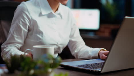 Close-up-of-office-clerk-looking-over-accounting-figures-on-laptop