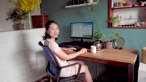 asian woman reading document on computer and working at home