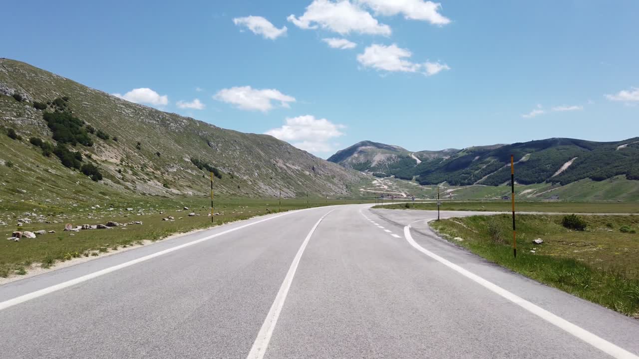 Veduta in movimento (auto, moto o bicicletta) di un paesaggio montano