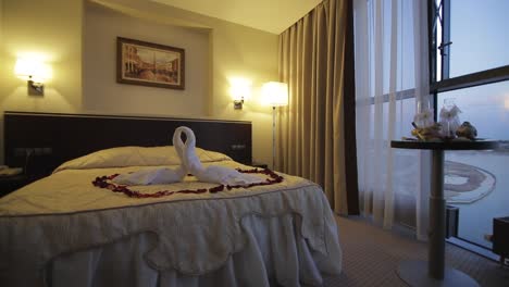 romantic hotel room with swan towels and rose petals